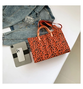 Detail view of quilted orange leopard print tote bag with shoulder strap and metal hardware
