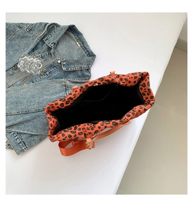 Detailed interior of orange leopard print tote bag with black lining and inner pocket