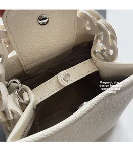 Detail der weißen Eimer-Tasche aus Leder mit silbernem Magnetverschluss und Verschluss