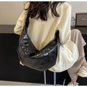 Detailed view of the black leather croissant bag with stylish knotted shoulder strap