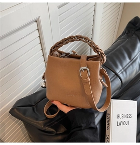 Detailansicht braune Beuteltasche mit Flechtgriff aus Leder und Metallverzierung