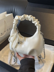 Beige faux leather cloud handbag with pearl bow charm and silver chain strap