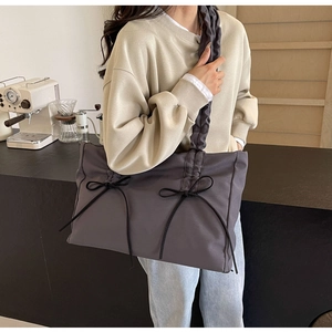 Detailed view of the dark grey pleated tote bag with bow design and ruffles
