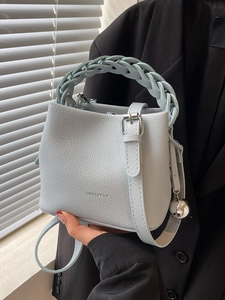 Stilvolle hellblaue Eimertasche mit geflochtenem Griff und verstellbarem Gurt