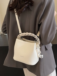 Cremeweiße Bucket Bag aus genarbtem Leder mit gewebtem Griff und silbernem Metallanhänger