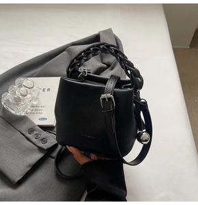 Schwarze Eimer-Tasche aus Leder mit geflochtenem Griff und verstellbarem Schultergurt
