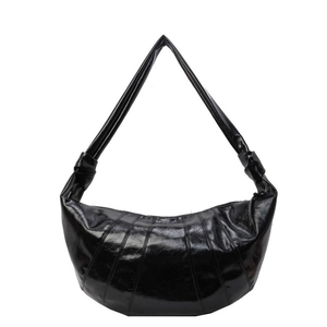 Glossy black croissant shoulder bag with stitched panels and knotted strap details