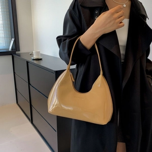 Minimalist beige glossy patent leather hobo bag with moon shaped shoulder strap