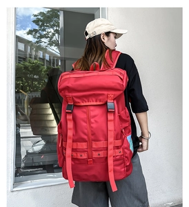 Dettaglio dello zaino rosso outdoor con chiusura a patta e sistema a cinghie MOLLE