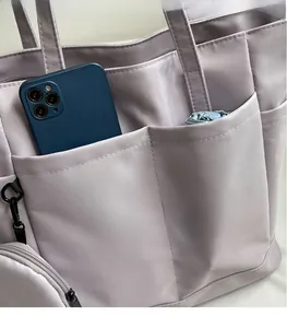Detailansicht der wasserfesten Nylon-Tasche mit Fronttaschen für Handy und Regenschirm