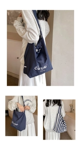 Three-way view of large canvas tote bags in solid navy and stripes on a model