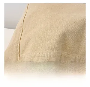 Close-up of thick beige canvas fabric texture with durable double-needle stitching detail