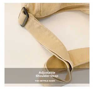 Detail showing adjustable shoulder strap buckle and texture of beige nylon messenger bag