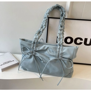 Pleated light blue tote bag with decorative bow ties and ruffled shoulder strap