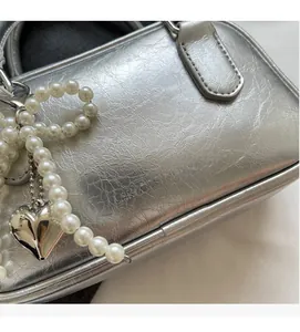 Close-up of silver bowling bag showing crushed leather texture and pearl charms