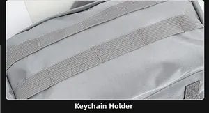 Dettaglio del tessuto in nylon grigio con sistema MOLLE per portachiavi e accessori