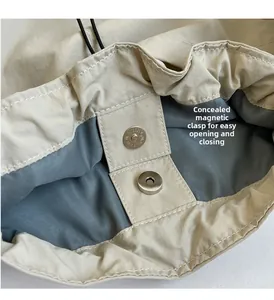 Detail view of the beige nylon tote bag featuring a hidden magnetic closure and drawstring