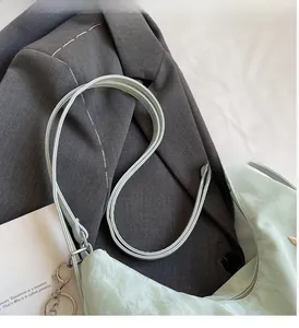 Detail view of light green pleated tote bag with silver hardware and shoulder straps