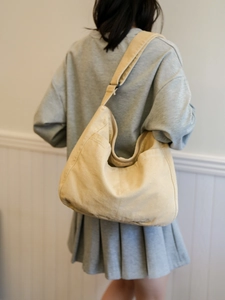 Detailed back view of a beige large-capacity nylon messenger bag with adjustable strap