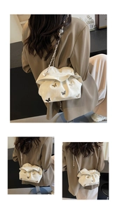Détail montrant des papillons métalliques 3D et du cuir plissé sur ce sac nuage crème