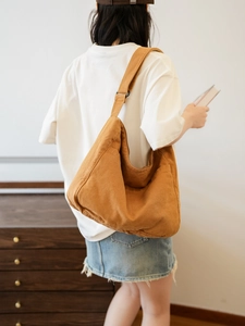 Detail of the mustard yellow canvas messenger bag with adjustable shoulder strap