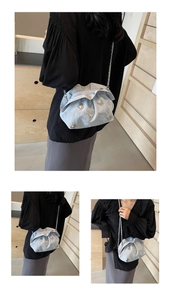 Détail du sac nuage plissé bleu clair avec papillon doré et bandoulière chaîne