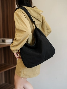 Close-up of black canvas hobo bag showing large capacity and soft fabric texture on model