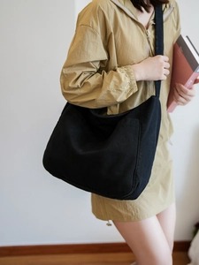 Detail view of high-density black nylon messenger bag with functional side pocket
