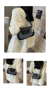 Detailed side view of polka dot underarm bag featuring a pearl bow heart charm