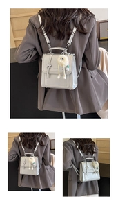 Nahaufnahme eines silbernen Mini-Rucksacks mit Metallstern und Plüsch-Anhänger