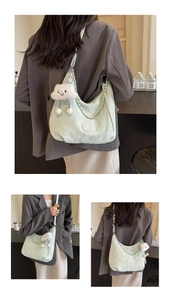 Detail of mint green crescent bag with pleats, silver chain and white plush cloud charm