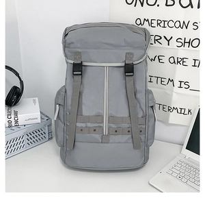 Dettaglio dello zaino grigio con fibbia e cinghie funzionali per lo stile outdoor