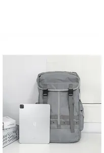 Zaino grigio con chiusura a coulisse e fibbia accanto a un iPad per confronto taglia
