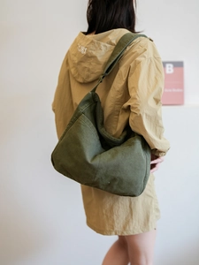 Detail of a large olive green canvas hobo bag showing the wide adjustable shoulder strap