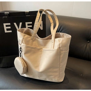 Detailansicht der beigen Nylon-Tragetasche mit vielen Taschen und passender runder Münztasche