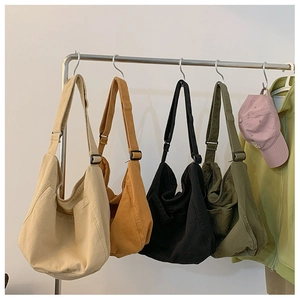 Row of large nylon hobo messenger bags in cream, brown, black and olive green