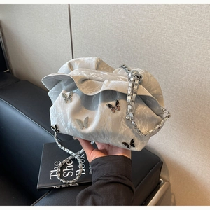 Détail du sac nuage plissé métallisé avec charms papillons argentés et chaîne