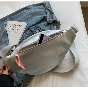 Borsa a tracolla argento metallizzato con cerniera rosa su sfondo casual lifestyle