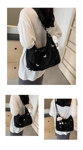 Detail of black butterfly hobo bag with white embroidery and plush cloud keychain
