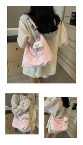 Detail of pink nylon shoulder bag with silver chain and white cloud plush pendant charm
