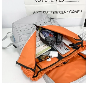 Vista interna dello zaino grigio con coulisse, fodera arancione e ampio spazio interno