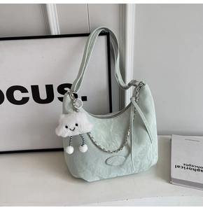 Detail of mint green ruched shoulder bag with cloud pendant and silver chain strap