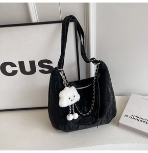 Close-up of black tote bag featuring crinkled texture, chain detail and cloud charm