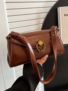 Retro dark brown baguette bag in glossy oil wax leather with round gold buckle detail