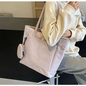 Detail der helllila wasserdichten Nylon-Tragetasche mit passender runder Münztasche am Gurt