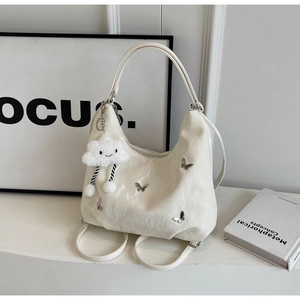 Detail of hobo bag with pleated leather, metal butterflies and plush cloud charm