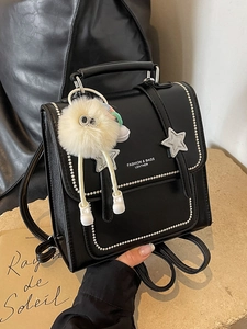 Silberner Damen-Rucksack aus schwarzem Leder mit Stern-Details und Plüsch-Anhänger