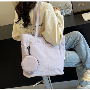 Detailansicht der fliederfarbenen Nylon-Tragetasche mit Vordertaschen am Modell