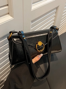 Glossy black patent leather baguette shoulder bag with gold metal ring detail and texture