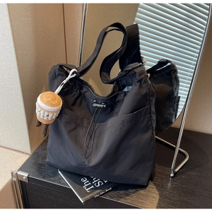 Detail of nylon tote bag with drawstring pocket and coffee cup plush charm